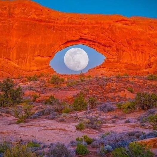 nearly full moon rising perfectly into the North Window Arch in Arches National Park in Moab, Utah.jpg